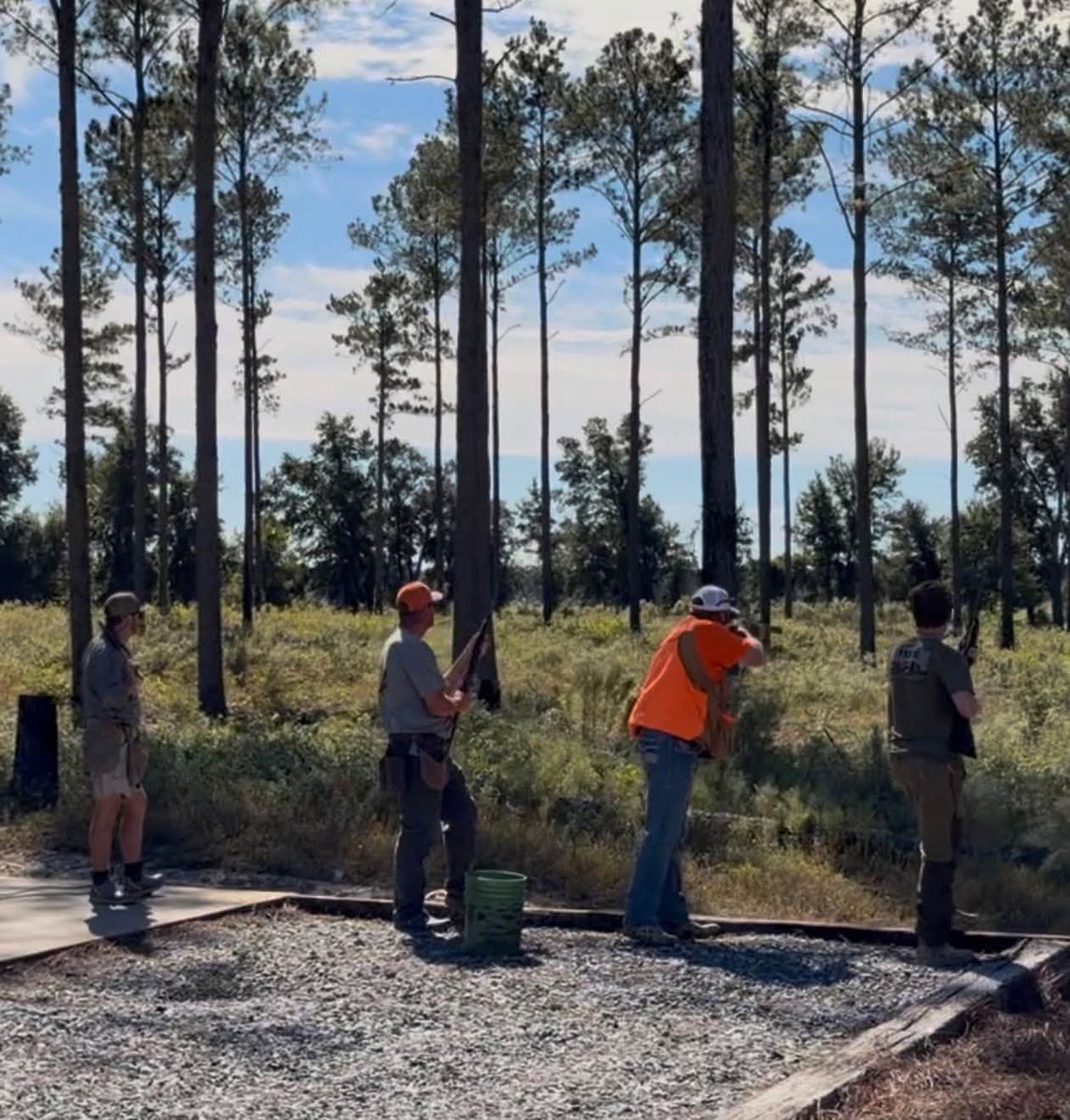 Hunters warming up on the skeet range under longleaf pines